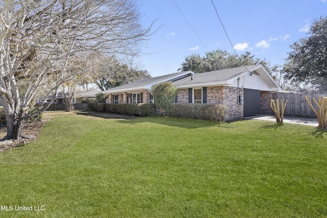 view of property exterior featuring fence, a lawn, and brick siding