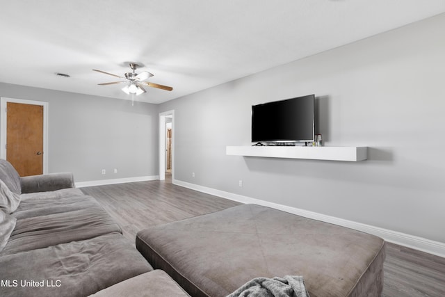 living area with ceiling fan, wood finished floors, and baseboards