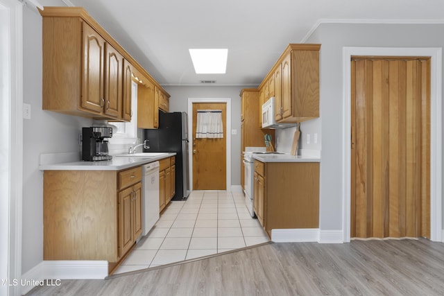 kitchen featuring white appliances, a skylight, visible vents, light countertops, and light wood-type flooring