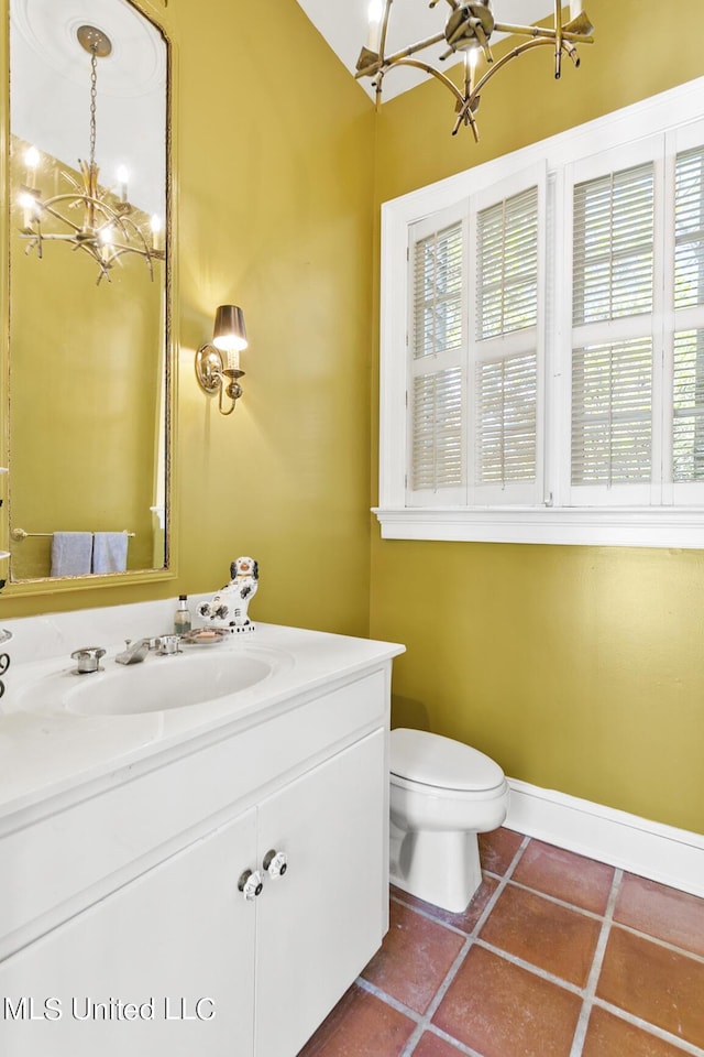 bathroom with an inviting chandelier, tile patterned floors, toilet, and a wealth of natural light