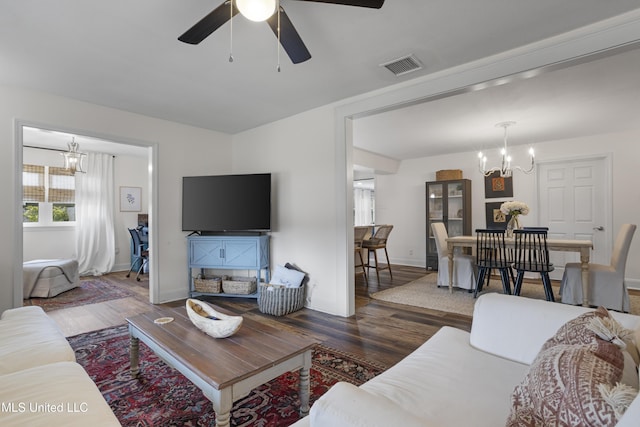 living area with baseboards, ceiling fan with notable chandelier, wood finished floors, and visible vents