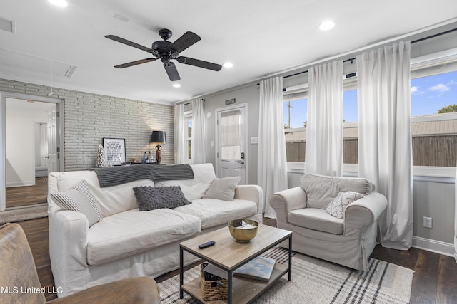 living area featuring a healthy amount of sunlight, a ceiling fan, attic access, and wood finished floors
