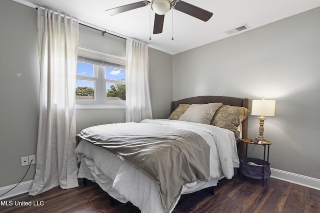 bedroom featuring a ceiling fan, baseboards, visible vents, and wood finished floors