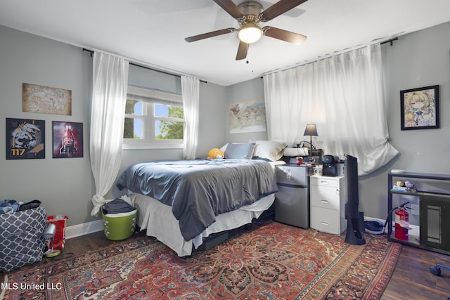 bedroom with baseboards, ceiling fan, and wood finished floors