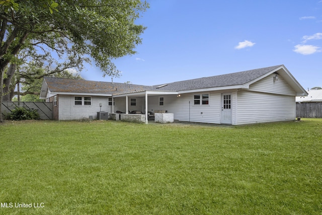 rear view of house featuring fence, central AC unit, a lawn, and roof with shingles