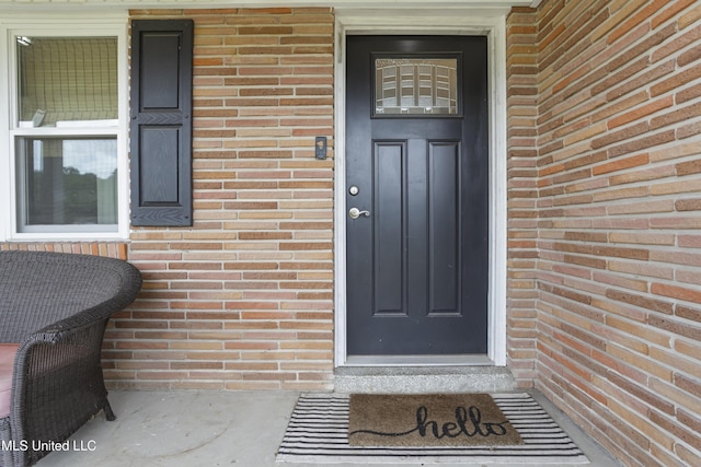 view of exterior entry with brick siding