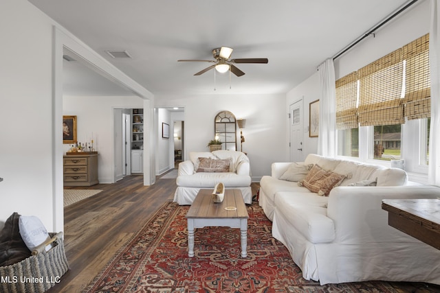 living area with dark wood-style flooring, a ceiling fan, baseboards, and visible vents