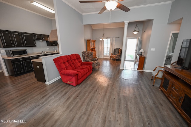 living room with dark wood-type flooring, ceiling fan, and crown molding