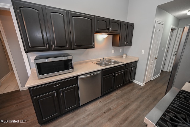 kitchen with dark wood-type flooring, stainless steel appliances, and sink