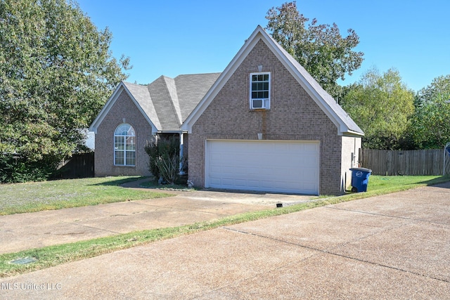 6126 Rolling Oaks Cv, Olive Branch, MS 38654 - traditional-style home featuring brick siding, a garage, fence, and a front yard