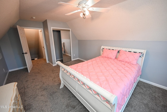 bedroom featuring a textured ceiling, vaulted ceiling, dark carpet, and ceiling fan