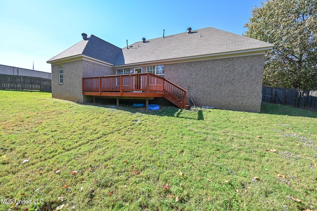 rear view of house with a deck and a lawn