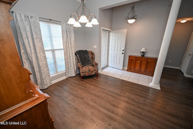 unfurnished room featuring decorative columns and light wood-type flooring