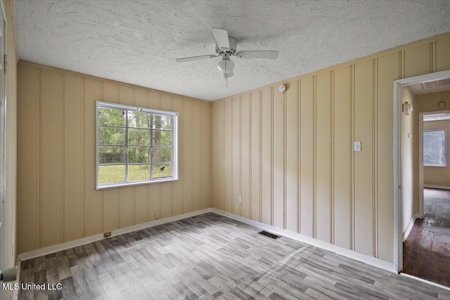 2862 Oak Forest Dr, Jackson, MS 39212 - spare room featuring wood finished floors, ceiling fan, baseboards, and a textured ceiling