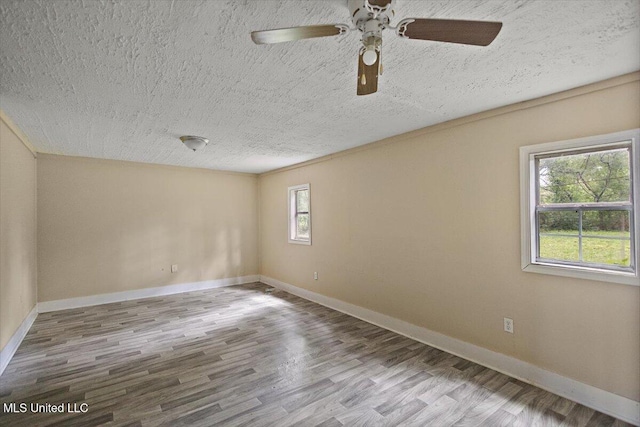 2862 Oak Forest Dr, Jackson, MS 39212 - empty room with a textured ceiling, wood finished floors, a ceiling fan, and baseboards