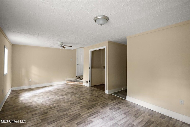 2862 Oak Forest Dr, Jackson, MS 39212 - empty room with ceiling fan, wood finished floors, a textured ceiling, and baseboards