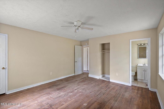 2862 Oak Forest Dr, Jackson, MS 39212 - unfurnished bedroom featuring wood finished floors, ensuite bathroom, a closet, a sink, and baseboards