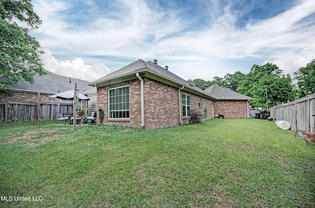 512 Sweetwater, Brandon, MS 39047 - rear view of property featuring brick siding, roof with shingles, a fenced backyard, and a lawn