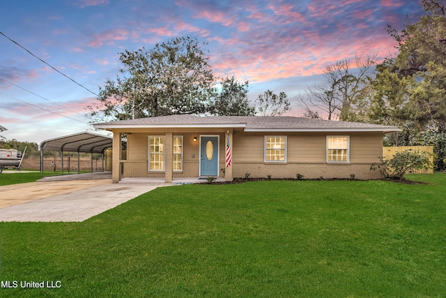 view of front facade featuring covered porch, a carport, and a yard