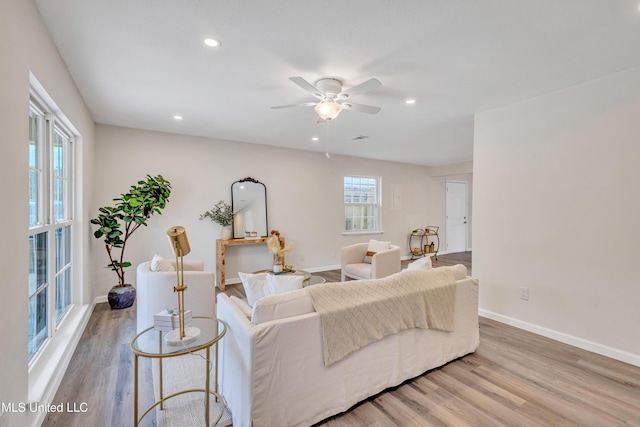 living room with light hardwood / wood-style floors and ceiling fan