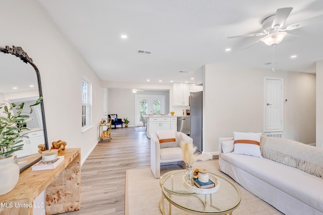 living room with ceiling fan and light hardwood / wood-style floors