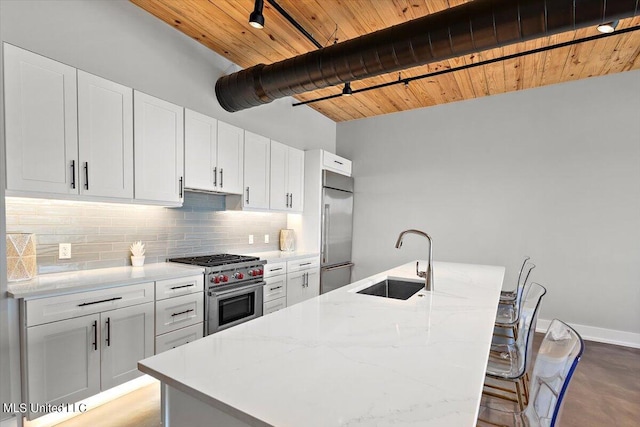 kitchen featuring sink, white cabinetry, a kitchen island with sink, and high quality appliances