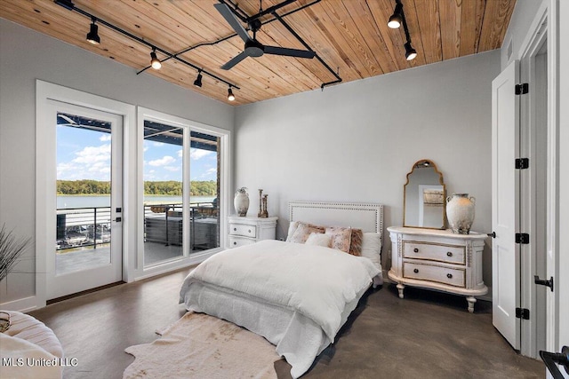 bedroom with a water view, access to outside, wooden ceiling, and rail lighting