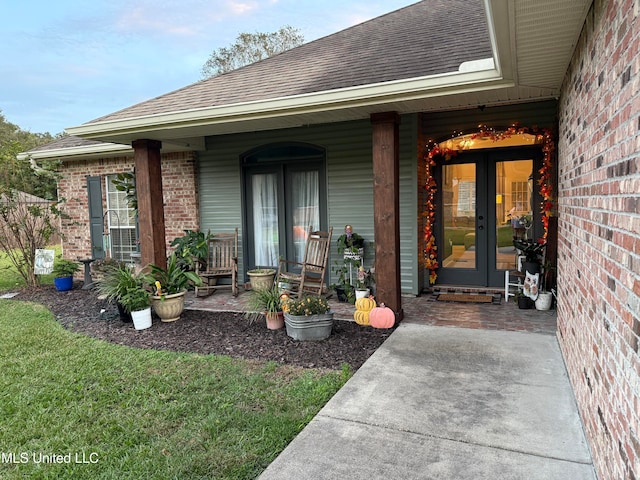 view of exterior entry with a porch and french doors