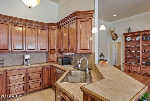 kitchen featuring black microwave, brown cabinetry, a sink, and crown molding