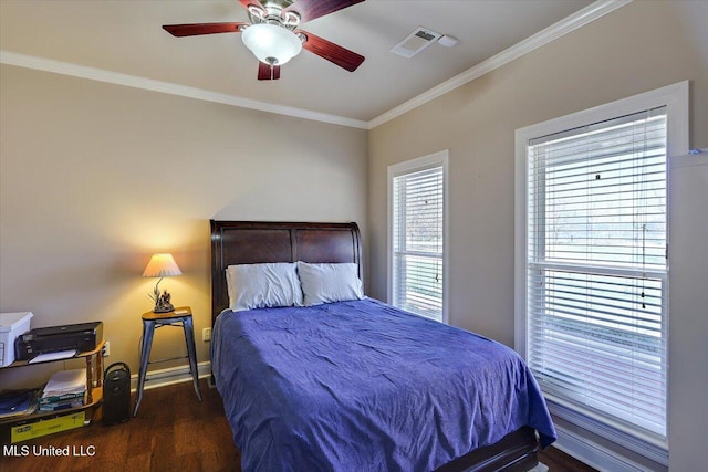 bedroom featuring visible vents, baseboards, a ceiling fan, wood finished floors, and crown molding