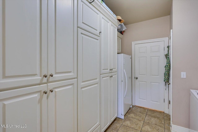 washroom featuring light tile patterned floors, independent washer and dryer, and cabinet space