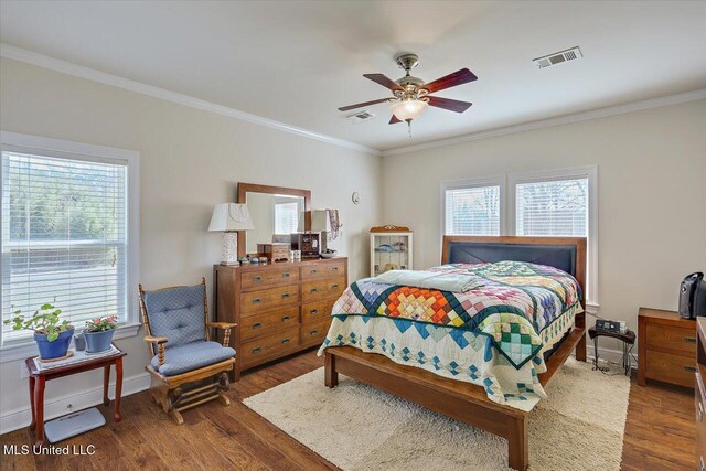 bedroom featuring multiple windows, visible vents, and wood finished floors