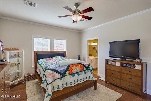 bedroom with connected bathroom, visible vents, dark wood finished floors, and crown molding