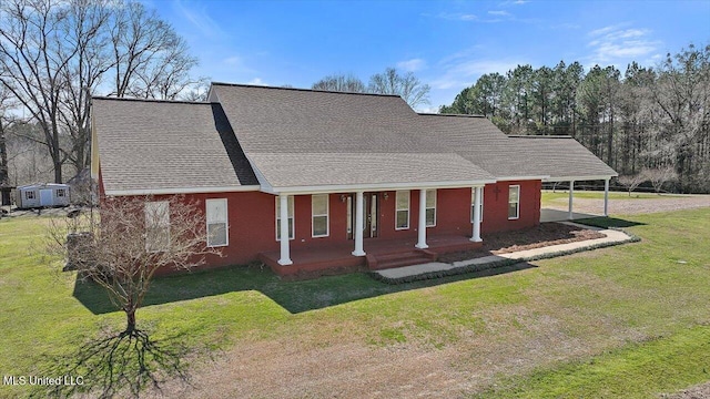 view of front facade featuring a front yard, covered porch, and roof with shingles