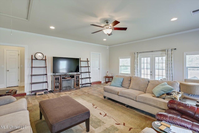 living area featuring ornamental molding, a wealth of natural light, and attic access