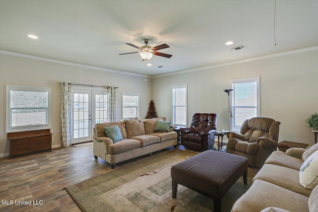 living area with visible vents, ornamental molding, wood finished floors, and french doors