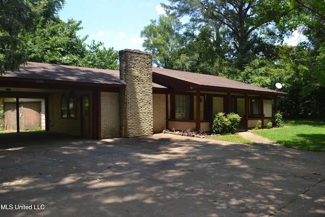 236 E Moon St, Ridgeland, MS 39157 - view of front facade featuring a chimney, concrete driveway, brick siding, and an attached carport