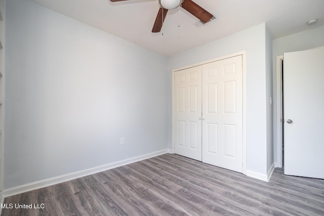 unfurnished bedroom with ceiling fan, a closet, and hardwood / wood-style floors