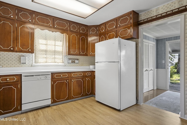 kitchen featuring white appliances, light hardwood / wood-style floors, and a wealth of natural light