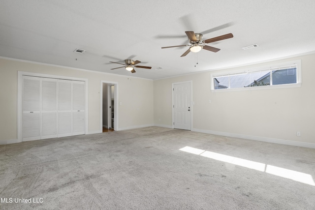 interior space featuring ceiling fan, light colored carpet, crown molding, and a textured ceiling