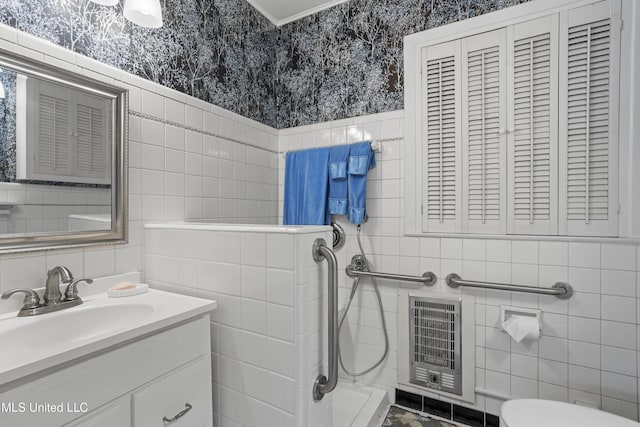 bathroom featuring tile walls, toilet, vanity, and heating unit