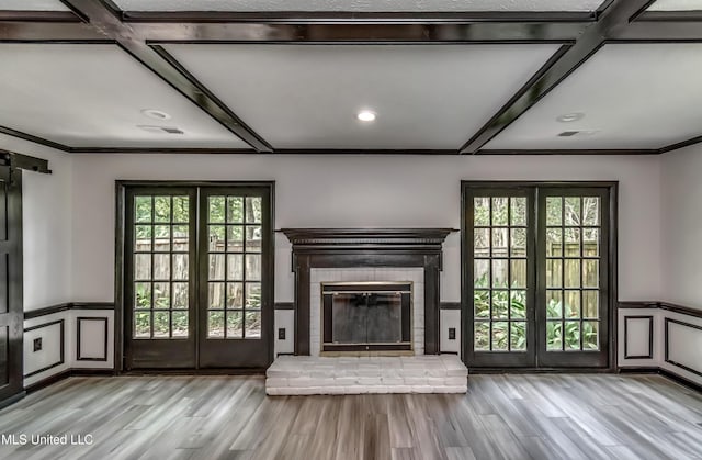 767 Sherwood Dr, Jackson, MS 39216 - unfurnished living room with a decorative wall, healthy amount of natural light, wood finished floors, wainscoting, and a brick fireplace