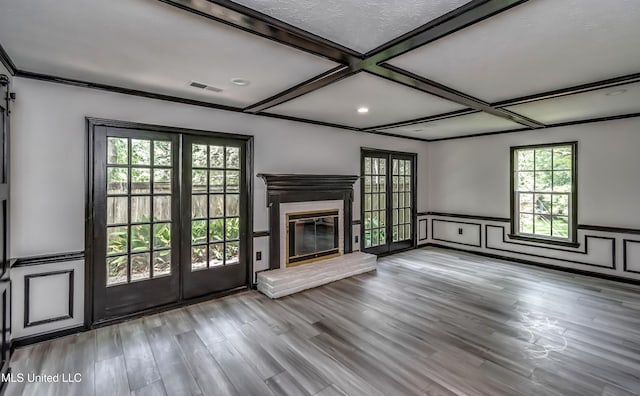 767 Sherwood Dr, Jackson, MS 39216 - unfurnished living room with coffered ceiling, plenty of natural light, wainscoting, wood finished floors, and a glass covered fireplace