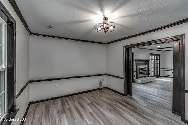767 Sherwood Dr, Jackson, MS 39216 - spare room with ornamental molding, wood finished floors, a textured ceiling, a fireplace with raised hearth, and baseboards