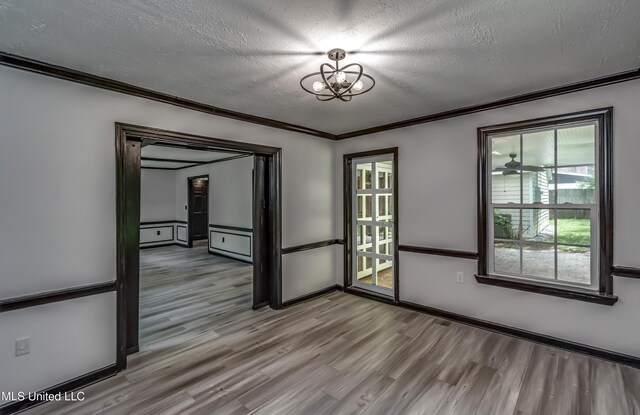 767 Sherwood Dr, Jackson, MS 39216 - spare room with wood finished floors, a textured ceiling, a chandelier, crown molding, and baseboards