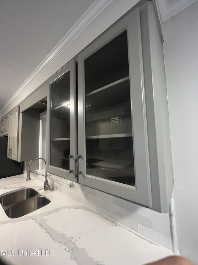 767 Sherwood Dr, Jackson, MS 39216 - detailed view of a sink, freestanding refrigerator, light stone counters, and ornamental molding