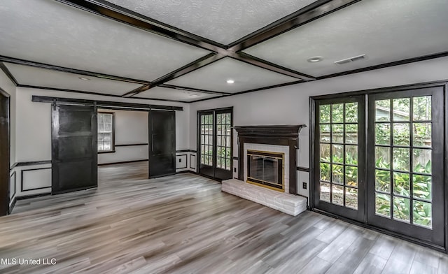 767 Sherwood Dr, Jackson, MS 39216 - unfurnished living room with a barn door, wood finished floors, coffered ceiling, a brick fireplace, and beamed ceiling