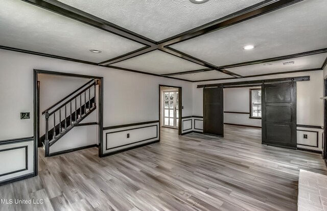 767 Sherwood Dr, Jackson, MS 39216 - unfurnished living room featuring stairs, wood finished floors, coffered ceiling, a textured ceiling, and a wainscoted wall