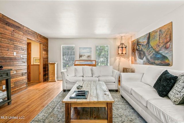 living room with light hardwood / wood-style flooring and wooden walls