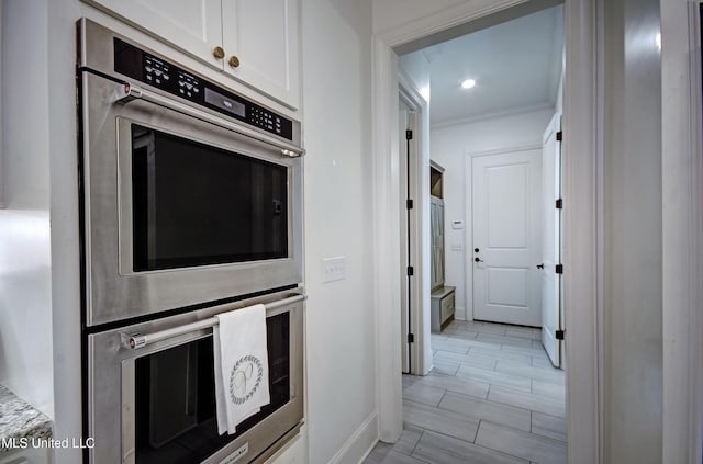 220 S Woodcreek Rd, Madison, MS 39110 - kitchen with stainless steel double oven, white cabinetry, and ornamental molding